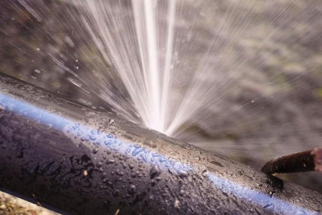 Water leaking from a damaged pipe with a high-pressure burst
