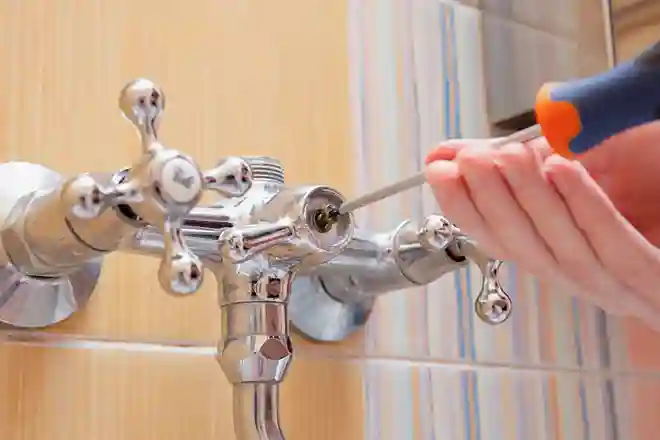 Plumber repairing a wall-mounted bathroom tap
